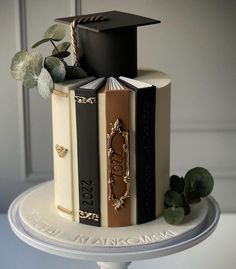 a cake decorated with books and a graduation cap