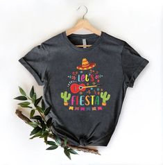 Lets Fiesta Shirt, Mexican Party Shirt, Womens Cinco De Maya Gift, Mexico Fiesta Themed Bachelorette Shirts, Hispanic Drinking Party Shirts HOW TO ORDER 1-) Please, check and review all the photos. 2-) Choose your t-shirt size and color. *Different styles of shirts may have different shades of the same color choice due to different manufacturer brands. *For this reason, we recommend matching shirts from the same styles if you want precisely matching colors (ex. Unisex, V-necks, Toddler, etc.). 3 Casual Multicolor Shirt For Cinco De Mayo, Novelty Printed Cotton Tops, Casual Tops With Graphic Print For Festivals, Casual Graphic Print Tops For Festivals, Printed Cotton Novelty Tops, Funny Print Short Sleeve Shirt For Cinco De Mayo, Multicolor Crew Neck Shirt For Cinco De Mayo, Multicolor Letter Print Tops For Cinco De Mayo, Fun Cotton Tops For Cinco De Mayo