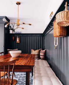 a wooden table sitting in the middle of a room next to a wall with hanging lights