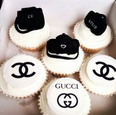 cupcakes with white frosting decorated with black and white gucci logo on them