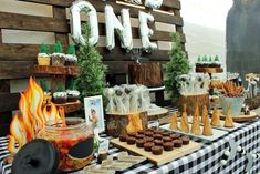 a table topped with cupcakes and cakes next to a sign that says one