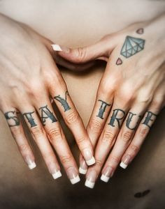 two women with tattoos on their hands and one has the words stay true written on her fingers