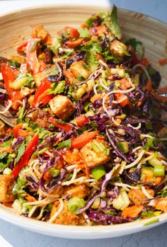 a white bowl filled with lots of different types of food on top of a table