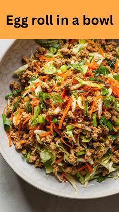 an egg roll in a bowl with lettuce, carrots and ground beef