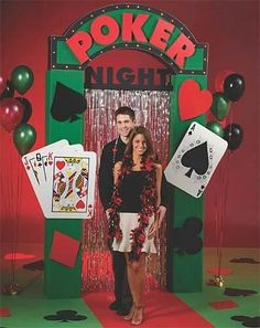 a man and woman standing in front of a booth at a poker night with balloons