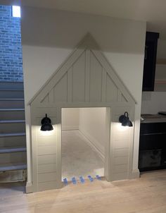 two black bells are on the side of a white wall in a room with wood flooring