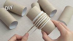 someone is wrapping up some toilet paper rolls with twine and string to make them look like they are holding something in their hands