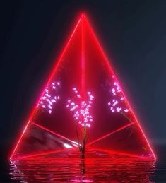 a red triangle shaped object floating on top of water with fireworks coming out of it