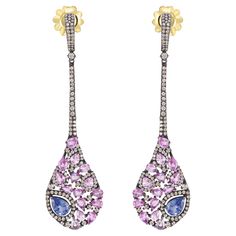 Introducing our Victorian 7.28 Cttw. Sapphire and Diamond Long Drop Earrings in 18K/925 – a captivating blend of timeless elegance and modern design. These exquisite earrings feature a marquise-shaped drop that gracefully dangles, adorned with pear-shaped blue and pink sapphires. Each gem is embraced by a dazzling diamond halo, set against the dark allure of black rhodium. The meticulous arrangement of diamonds on the drop creates a harmonious symphony of light and color, adding depth and dimension to the overall design. The drop is seamlessly connected to the surmount by a row of diamond-studded frames, providing a fluid transition between the elements. The surmount, adorned with additional diamonds, adds a touch of sophistication and completes the ensemble. The closures, crafted from 18k Diamond Choker Necklace, Alexis Bittar Jewelry, Diamond Choker, Long Drop Earrings, Alexis Bittar, Black Rhodium, Dream Jewelry, Diamond Halo, Sapphire Diamond