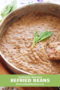 mexican refried beans in a large pot with fresh basil on top and the words authentic mexican refried beans above it