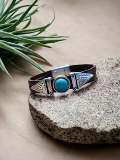 This leather bracelet is a bestseller and a must-have for any boho-chic wardrobe. Handmade with genuine leather, the bracelet features a striking turquoise stone in the center, surrounded by Southwest-inspired designs. The cuff style allows for a comfortable fit, making it a versatile accessory that can be dressed up or down. The unique indie style of this bracelet makes it a standout piece of jewelry that is sure to turn heads. Whether you're looking to add some bohemian flair to your outfit or Bohemian Leather Bracelet For Festivals, Bohemian Turquoise Leather Cuff Bracelet, Blue Leather Bracelets For Festival, Blue Leather Festival Bracelets, Turquoise Leather Bohemian Cuff Bracelet, Southwestern Style Turquoise Leather Bracelet For Festivals, Bohemian Leather Cuff Bracelet, Bohemian Turquoise Leather Bracelet, Turquoise Bohemian Leather Bracelet