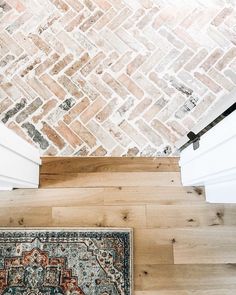 a rug on the floor next to a brick wall