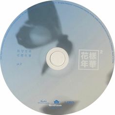 the shadow of a person's hand on top of a cd disc with chinese writing