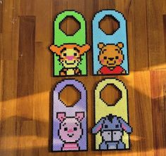 four door hangers made out of perler beads on a wooden floor with one bear and the other pig