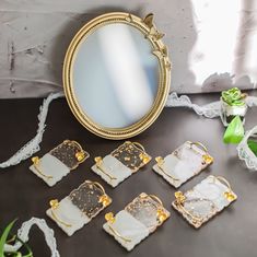 there are many pieces of gold and white glass on the table next to a mirror