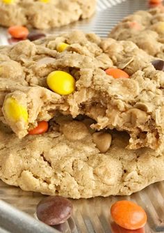 two cookies with candy corn and m & m's are on a cookie sheet