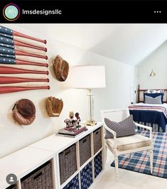 an american flag is hanging on the wall above a bed in a bedroom with white walls