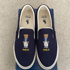 Brand New- Never Worn Nor Tried On!Awesome Stylish Slip On Casual Canvas Signature Polo Bear Shoes In Navy Blue By Ralph Lauren Comes In All Original Packaging! Hard To Find Size! 100% Authentic Polo Shoes Mens, Blue Sneakers With Embroidered Logo And Round Toe, Blue Round Toe Sneakers With Embroidered Logo, Blue Sneakers With Embroidered Logo, Designer Blue Slip-on Sneakers, Polo Outfits, Pony Sneakers, Bear Shoes, Polo Ralph Lauren Shoes