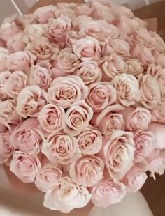 a woman holding a bouquet of pink roses