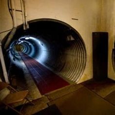 an image of a tunnel going through the wall with lights coming from it and some speakers on either side