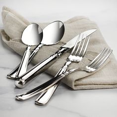 three forks and two spoons sitting on top of a napkin