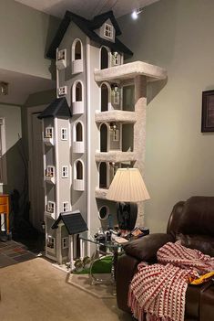 a living room filled with furniture and a tall cat tree in the middle of it