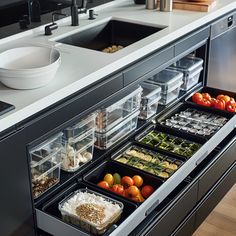 an open drawer in a kitchen filled with food