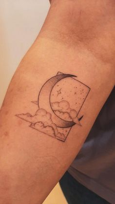 a man with a tattoo on his arm that has the moon and clouds in it