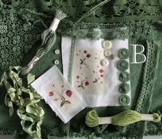 the table is covered with green lace and embroidered items