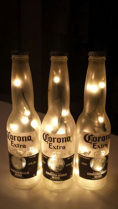 three bottles with lights on them sitting on a table