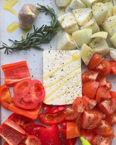 sliced tomatoes, cheese and other vegetables on a cutting board