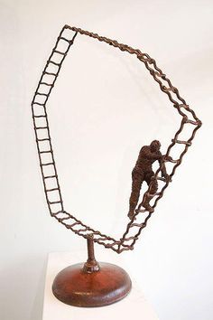 a metal sculpture with a man climbing on a ladder