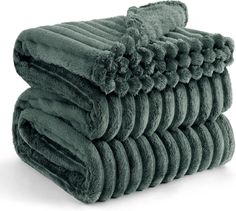 stack of towels folded on top of each other in dark green color, isolated on white background