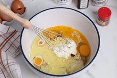 a bowl filled with eggs and cream next to other ingredients