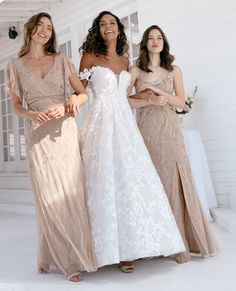 three women standing next to each other in dresses