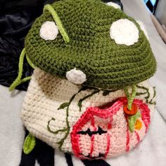 two crocheted hats sitting on top of each other next to a stuffed animal