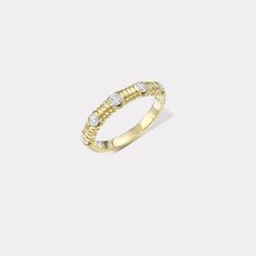 a yellow gold ring with three diamonds on the top and bottom, set against a white background