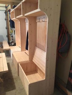 a wooden bench with two benches built into it and some shelves on the wall behind it