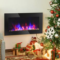 a christmas tree and presents in front of a fireplace with the fire glowing brightly on it