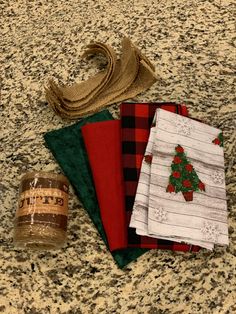 three napkins, one with a christmas tree on it and the other with plaid