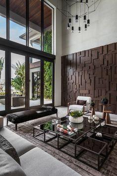 a living room with couches, coffee table and large windows