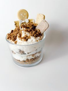 a dessert in a glass bowl topped with whipped cream, cookies and other toppings