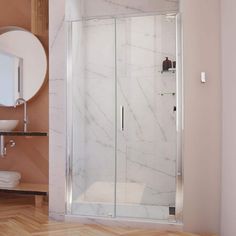 a bathroom with a walk in shower next to a sink and mirror on the wall