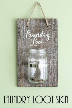 a wooden sign hanging on the side of a wall next to a jar filled with coins