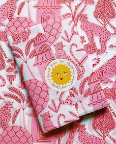 a pink and white fabric with an image of a hedge on the front, surrounded by pineapples