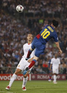 two men playing soccer in front of a crowd