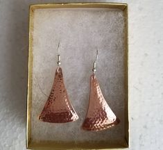 Hammered copper earrings with a sterling silver ear wire. The hammering technique I do domes them slightly for a nice effect, and hardens the metal a little so they hold their shape well. They are available in size small, 7/8ths of an inch long, medium, 1&1/4 inch long, and large 1&5/8ths of an inch. That is the length of the hammered piece. The ear wire adds about a 1/2 inch. They are not heavy. Shipped in a gift box to protect during shipment. I also have this style listed in sterling Hammered Copper Drop Earrings, Hammered Copper Earrings For Gift, Hammered Silver Copper Earrings, Hammered Silver Earrings Made Of Copper, Silver Hammered Copper Earrings, Hammered Rose Gold Copper Earrings, Rose Gold Hammered Metal Earrings, Hammered Copper Earrings, Hammered Copper