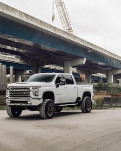 a white truck parked in front of a bridge