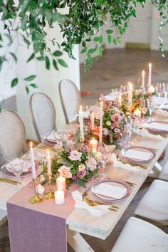 the table is set with candles, plates and napkins for an elegant dinner party