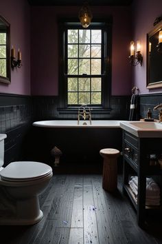 a bathroom with dark wood floors and purple walls, along with a claw foot tub